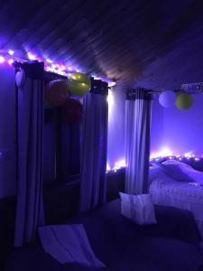 a bedroom with a bed with purple lights and balloons at Croft B&B Accommodation With Hot Tub in Gamrie