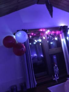 a room with a window with balloons and christmas lights at Croft B&B Accommodation With Hot Tub in Gamrie