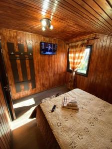 um quarto com uma cama num quarto de madeira em Casa Alex Alunisu em Alunişu