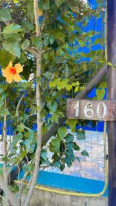 a sign that reads next to a tree at Mar e Lua Flats - Maresias in Maresias