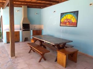 a table and benches in a room with a kitchen at Mar e Lua Flats - Maresias in Maresias