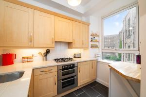 a kitchen with wooden cabinets and a stove top oven at The Palais in Dundee