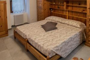 Residenza Cotruta Spiazzo في سبياتزو: غرفة نوم بسرير كبير مع اطار خشبي