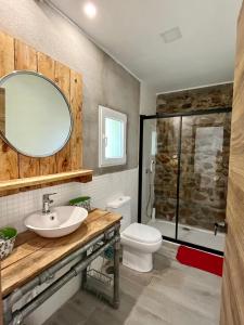 a bathroom with a sink and a toilet and a mirror at Stone Garden, Casa en plena naturaleza in Uceda