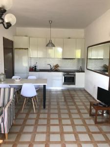a kitchen with white cabinets and a table and chairs at Daddy’s sea view house in Nea Irakleia