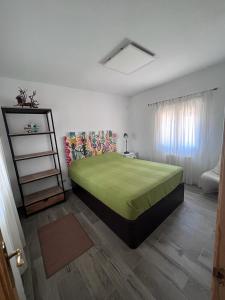 a bedroom with a green bed in a room at Stone Garden, Casa en plena naturaleza in Uceda