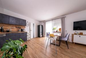 cocina y comedor con mesa y sillas en Ferienwohnung Leipzig- Hirschfeld Apartments, en Leipzig