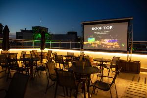 a group of tables and chairs on a balcony with a screen at Casa Nova Hotel in Rio de Janeiro