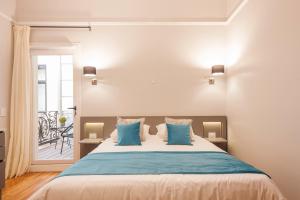 a bedroom with a large bed with blue pillows at Sarmiento Flats in Buenos Aires