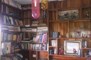 a living room with wooden book shelves filled with books at Diosa de la Montaña in Jama