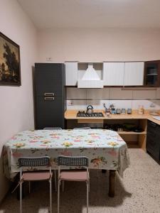 cocina con mesa, 2 sillas y nevera en Olivier House Mellieha en Mellieħa