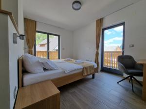 um quarto com uma cama, uma secretária e uma janela em Apartments Vila Darja em Bohinj