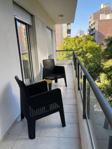two chairs sitting on the balcony of a building at Departamento Fabuloso 4 in Rosario