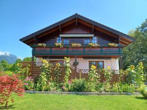 a house with a balcony and flowers in front of it at Appartement Panorama in Gröbming