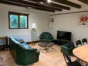 ein Wohnzimmer mit einem Sofa, Stühlen und einem Tisch in der Unterkunft Le Faubourg - Gîte et chambres d'hôte in Losne