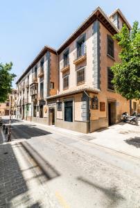 eine leere Straße mit einem großen Backsteingebäude in der Unterkunft Hostel Carlota Braun in Granada