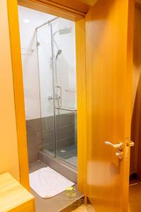 uma casa de banho com um chuveiro e uma porta de vidro em Golden Six Hotel and Restaurant em Lekki