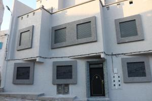a white building with windows and a door at Tiwaline Tarsime App A in Sidi Ifni