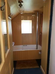 baño con bañera y ducha y ventana en 2 bed flat in Moray, near coast and Whisky Trail, en Keith
