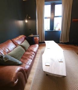 a living room with a leather couch and a coffee table at 2 bed flat in Moray, near coast and Whisky Trail in Keith