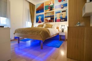 a bedroom with a bed with a painting on the wall at Rooms Indigo Bundek in Zagreb