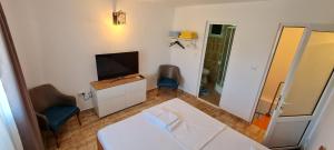 a bedroom with a bed and a tv and a chair at LaNoi LaVoi in Mangalia