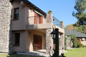 a stone house with a balcony and a door at Alto Chacras Cottage in Chacras de Coria