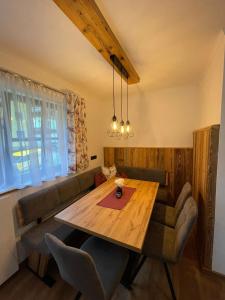 - une salle à manger avec une table en bois et un canapé dans l'établissement Ferienwohnung Rohrmoser mit 2 Schlafzimmern, à Hüttschlag