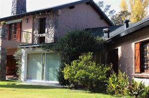 una casa con una gran ventana en el lateral en Alto Chacras Cottage en Chacras de Coria