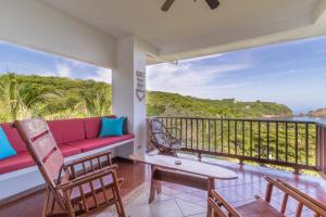 un soggiorno con divano e sedie su un balcone di Ocotal Beach Front Condo #38 a Ocotal