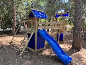 a playground with a blue slide and a ladder at Racar Hotel in Frigole