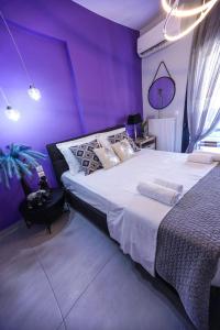 - une chambre violette avec un lit et un mur violet dans l'établissement Albatross Volos Luxury Apartment, à Vólos