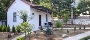 a garden in front of a white house at Okatse Lodge in Gordi
