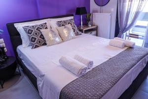 a large white bed with pillows on top of it at Albatross Volos Luxury Apartment in Volos
