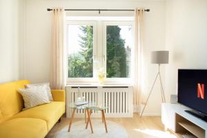 a living room with a yellow couch and a window at Löwe Apartments "Gelb" Tiengen Altstadt in Waldshut-Tiengen