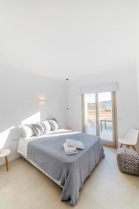 a white bedroom with a large bed with towels on it at CAMPO SUITES in Kampos Paros