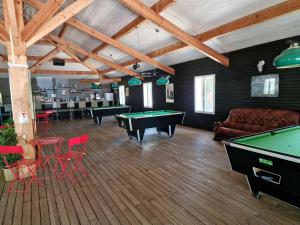 a room with ping pong tables and red chairs at Grand Mobile home dans camping in Mimizan