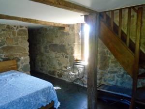 a bedroom with a bed and a staircase in a building at Charming House in Andeviso with Mountain View in Arcos de Valdevez