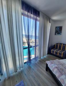 Schlafzimmer mit einem großen Fenster mit Meerblick in der Unterkunft Apartment "Palace" in Sonnenstrand