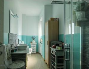 baño con paredes azules y blancas y lavabo en TORRE PELLICE Alloggio incantevole con parcheggio privato en Torre Pellice