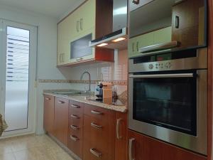 a kitchen with wooden cabinets and a stove top oven at A PONTE in Padrón