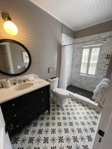 uma casa de banho com um lavatório, um WC e um espelho. em 52 Union em Nantucket
