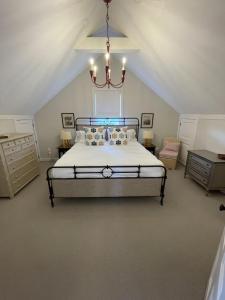 1 dormitorio con cama y lámpara de araña en 52 Union, en Nantucket