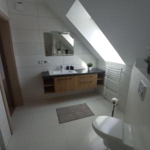 La salle de bains blanche est pourvue d'un lavabo et d'un miroir. dans l'établissement domek u fiedora, à Pieniążkowice