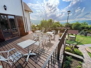 a wooden deck with tables and chairs on it at Villa Zoryany Dvir in Skhidnitsa