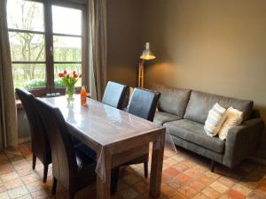De Burkelhoeve app.B في مالديخيم: غرفة معيشة مع طاولة وأريكة