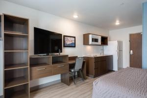 Una habitación de hotel con una cama y un escritorio con televisión. en WoodSpring Suites Smyrna-La Vergne, en Smyrna