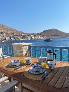 drewniany stół z jedzeniem i napojami na wodzie w obiekcie Halki Sea Breeze - a waterfront villa w mieście Chalki