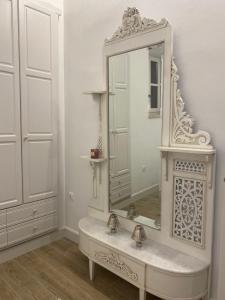 a white bathroom with a sink and a mirror at Halki Sea Breeze - a waterfront villa in Halki