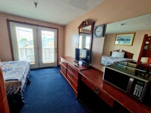 a hotel room with a bed and a mirror at Regal Inn Hampton Beach in Hampton